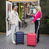 Two people with Tesport Cloud Collection navy and pink suitcases standing outside a building.
